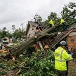 Large fallen tree damaging a home in Oklahoma after a severe storm while insurance claims are being assessed.